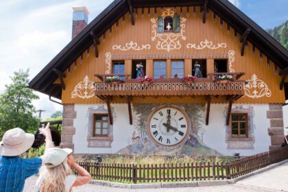 two people standing and looking at a cuckoo clock on a hotel