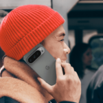 Man in red hat using Pixel 9 Pro for a phone call